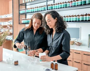 academic showing student how to pour liquid herbs in clinic | Torrens University
